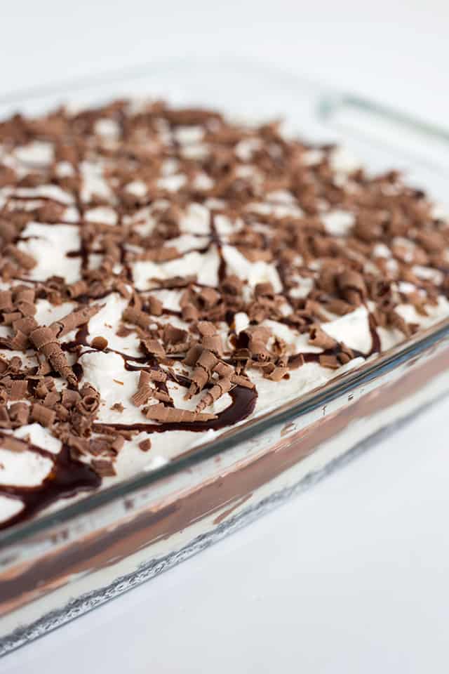Chocolate Lasagna - This chocolate lasagna is the perfect no-bake summer dessert. It has a chocolate cookie crust, cream cheese, chocolate ganache, pudding, and whipped cream. It's so easy to make and people will go crazy for it every single time. It's like biting into a soft, fluffy chocolate cloud on top of a cookie crust. #cookiedoughandovenmitt #chocolate #dessertrecipes #dessertfoodrecipes #dessertable #nobake #nobakedesserts