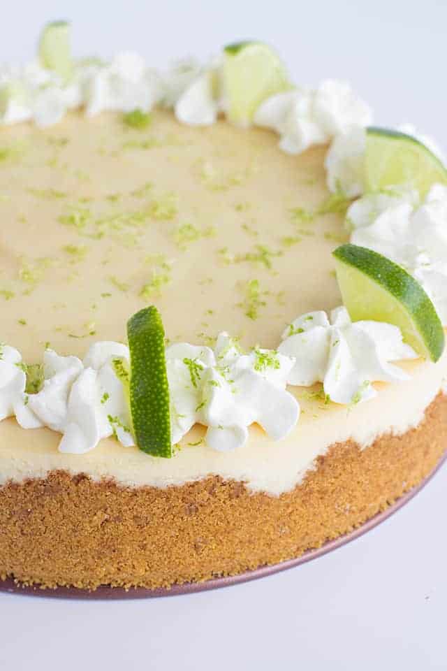 Key Lime Cheesecake - This key lime cheesecake is a fun spin on the key lime pie. It's so thick and creamy! Did I mention it has the perfect balance of sweet and tangy?! As far as the perfect summer dessert, this key lime cheesecake is the total package. #cookiedoughandovenmitt #cheesecake #cheesecakes #summerdessert #dessertfoodrecipes #dessertrecipes