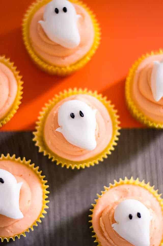 Ghost cupcakes with a dark wood and orange background