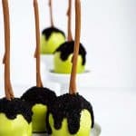 three Poison apple cake pops on a white plate