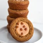stack of fudge filled gingerbread cookie cups with a cookie cup leaned against stack on a white plate