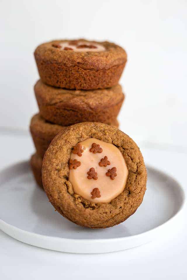 stack of fudge filled gingerbread cookie cups with a cookie cup leaned against stack on a white plate