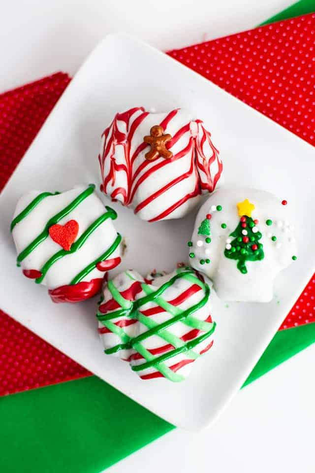 Ugly Sweater OREO Cookie Balls on a white plate with red and green fabric