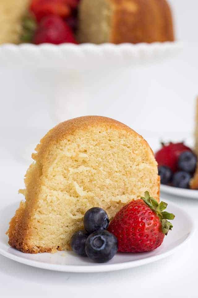 Vanilla Pound Cake Recipe - This buttery, vanilla pound cake recipe is perfect by itself or topped with fresh fruit. It's the perfect dense cake without being dry. Bake it up in your favorite bundt pan for a show-stopping dessert. #cake #vanilla #poundcake #dessertrecipe #cookiedoughandovenmitt