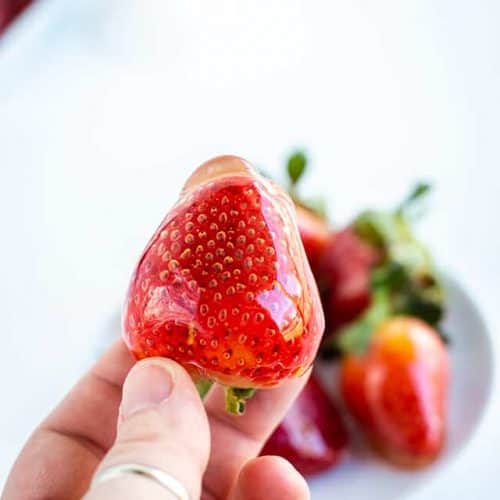 holding candied strawberries