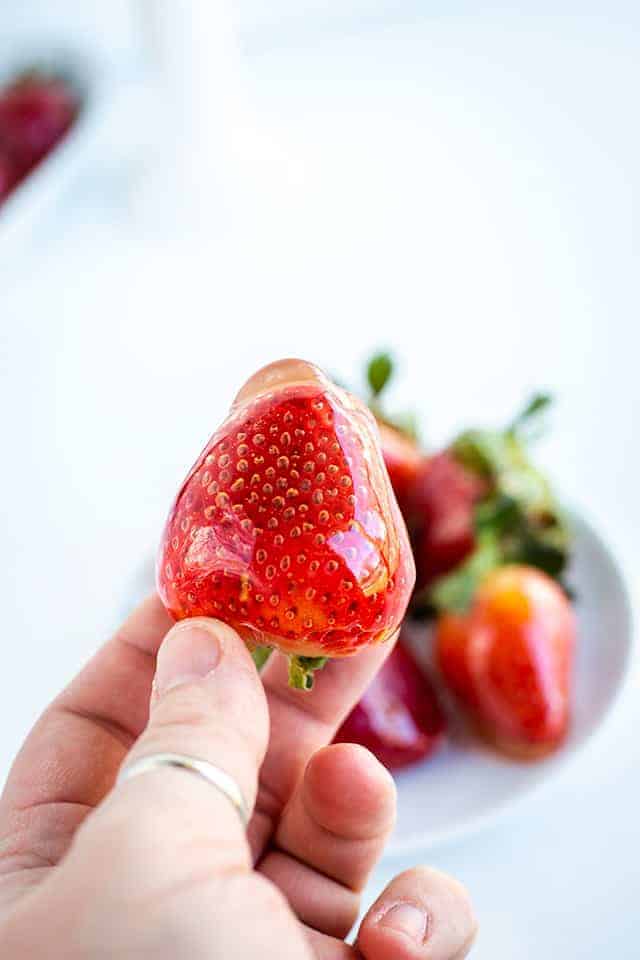 holding candied strawberries