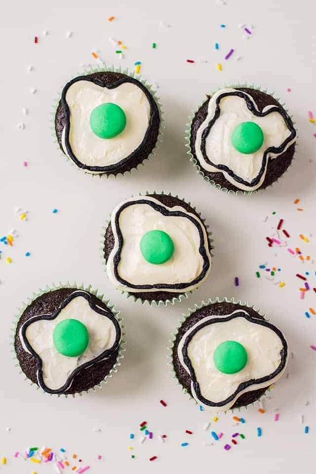 Dr. Seuss Cupcakes - These Dr. Seuss Cupcakes are a great recipe to make for a kid's party or with your child. What better way to celebrate Dr. Seuss's birthday on March 2nd than with a chocolate cupcake topped with green eggs made out of frosting?! #cookiedoughandovenmitt #cupcakes #dessertrecipe #easydessert #drseuss
