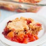 strawberry mandarin orange dump cake on a plate with glass pan