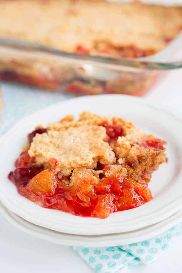 strawberry mandarin orange dump cake on a plate with glass pan