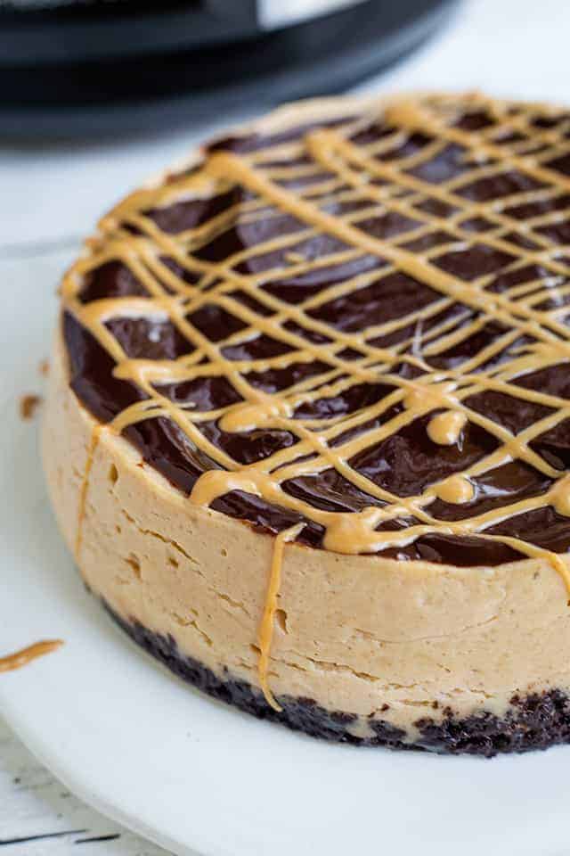 close up of side of instant pot peanut butter cheesecake on white background