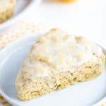 lemon poppy seed scone on white plate with polkadotted fabric