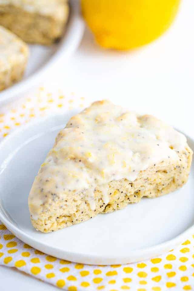 lemon poppy seed scone on white plate with polkadotted fabric