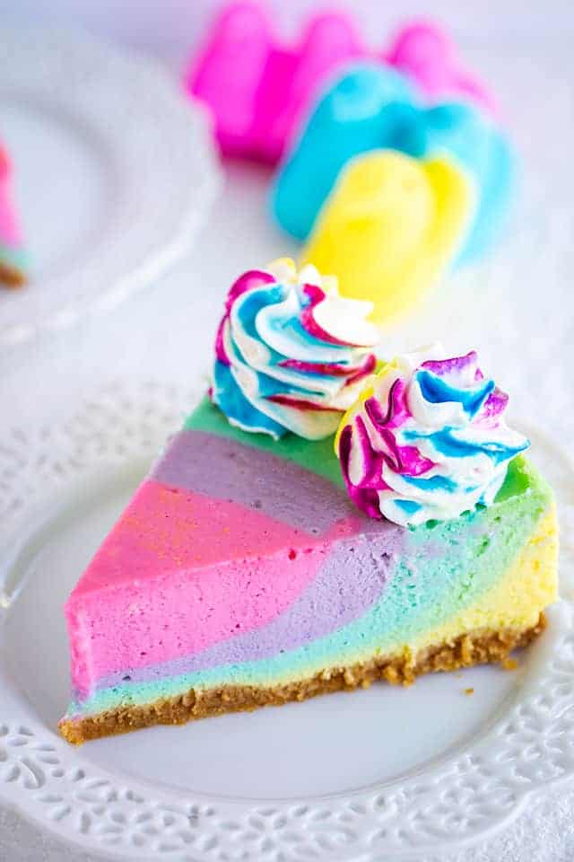 Peeps Marshmallow Cheesecake - This Peeps Marshmallow Cheesecake is a pastel rainbow cheesecake flavored with Peeps coffee creamer and marshmallow creme. It's makes the perfect Easter cheesecake or spring dessert! #cookiedoughandovenmitt #pastel #dessertfoodrecipes #dessertrecipes #cheesecakerecipes #easterdesserts #easter