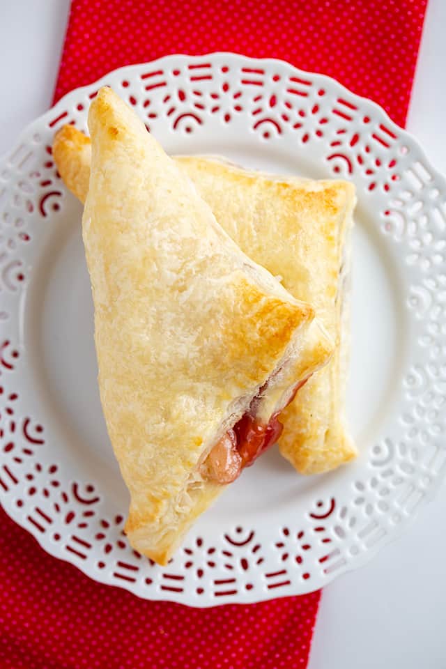 Strawberry Cream Cheese Turnovers - This easy strawberry cream cheese turnover recipe is flaky and delicious. Each turnover is stuffed with cream cheese and strawberry jam. They're brushed with an egg wash to give them a golden shell. #cookiedoughandovenmitt #breakfastrecipes #breakfast #strawberries #tunovers
