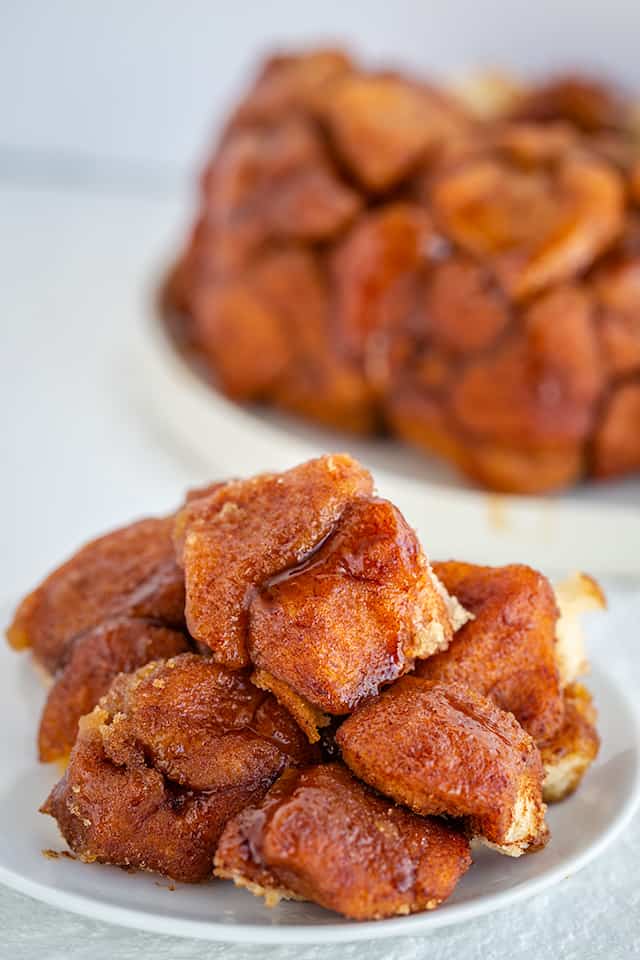 Instant Pot Monkey Bread - This Instant Pot Monkey Bread is so easy to make and tastes amazing! This monkey bread (Instant Pot) is one of my very favorites. Each piece of biscuit is coated in cinnamon and sugar before being added to the bundt pan. #cookiedoughandovenmitt #instantpot #instantpotrecipes #instantpotdesserts #instantpot #monkeybread #dessertfoodrecipes #dessertrecipes monkey bread close up view on a plate