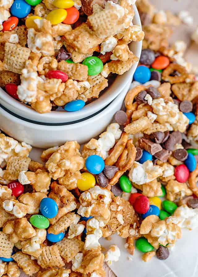 small white bowls of caramel chex mix and candies