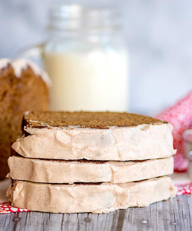 stack of gingerbread loaf showing off the cinnamon glaze with a glass of milk