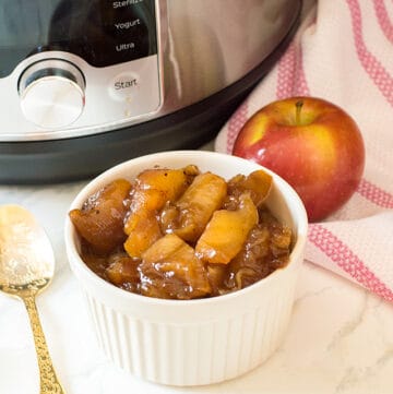 white ramekin with instant pot cinnamon apples and gold spoon