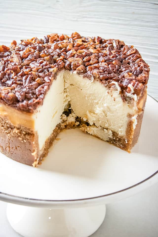 image of the pecan pie cheesecake on a white cake plate
