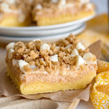 slice of sweet potato cheesecake bars on paper with yellow linen