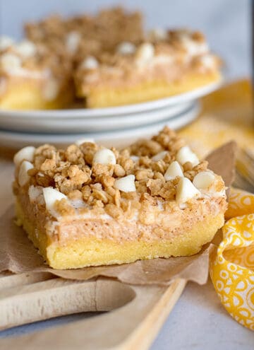 slice of sweet potato cheesecake bars on paper with yellow linen