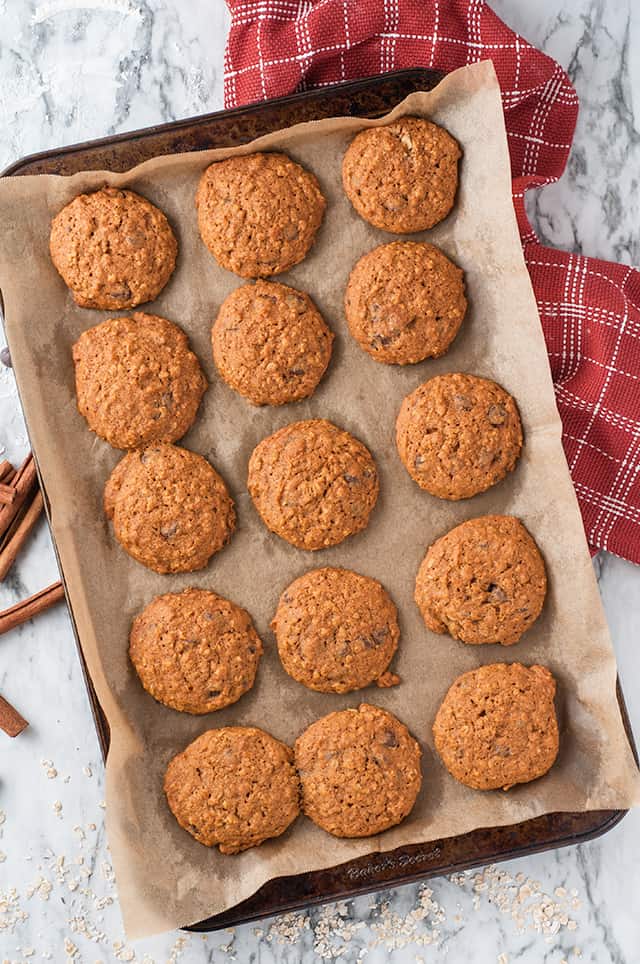 pumpkin oatmeal chocolate chip cookies on baking sheet with parchment paper