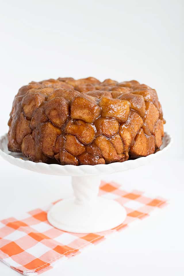 distant picture monkey bread on white cake plate with orange checkered linen