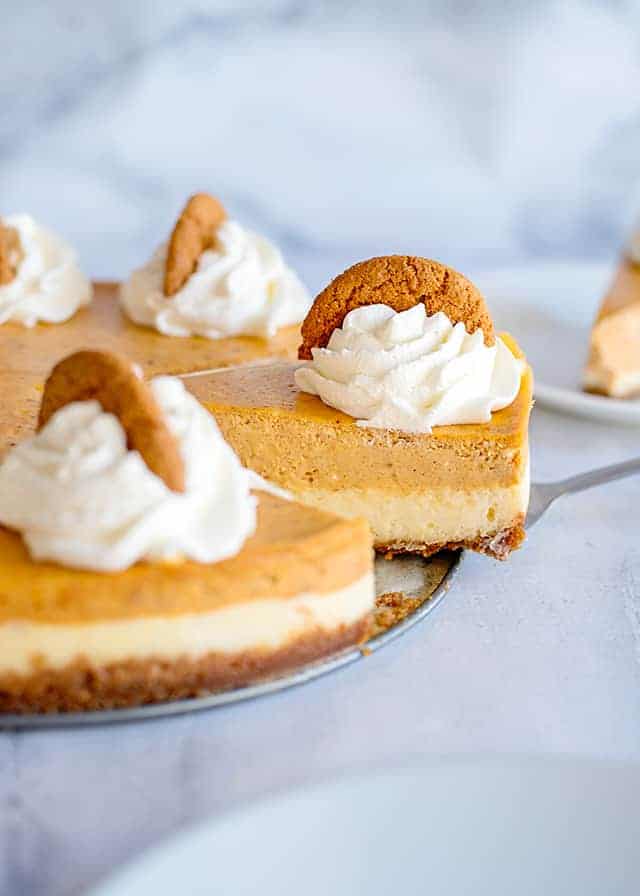 serving a slice of double layer pumpkin cheesecake