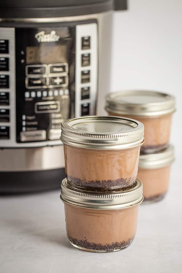 stack of sous vide cheesecakes in jars in front of Souspreme Multi Pot
