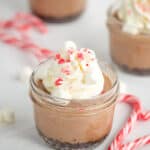 sous vide peppermint hot chocolate cheesecakes with whipped cream and crushed peppermint candy on top