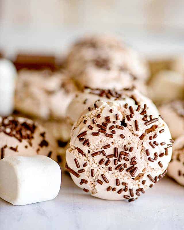 hot chocolate meringue cookie on its side with a large marshmallow