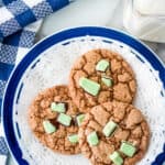 three andes mint cookies on a blue plate with a paper doily