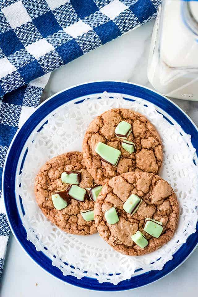 three andes mint cookies on a blue plate with a paper doily