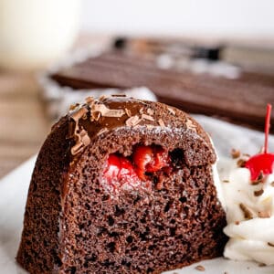 A slice of chocolate bundt cake with a cherry on top