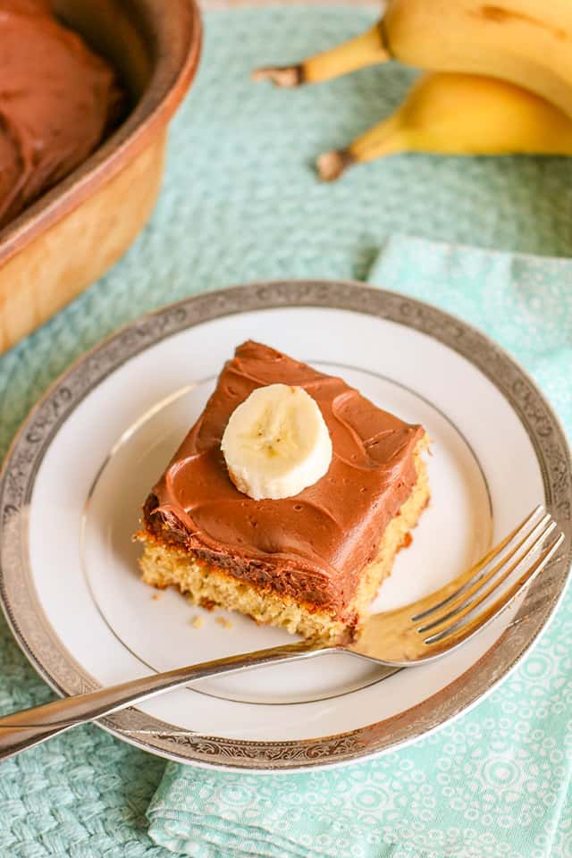 slice of banana cake on a white plate with a fork