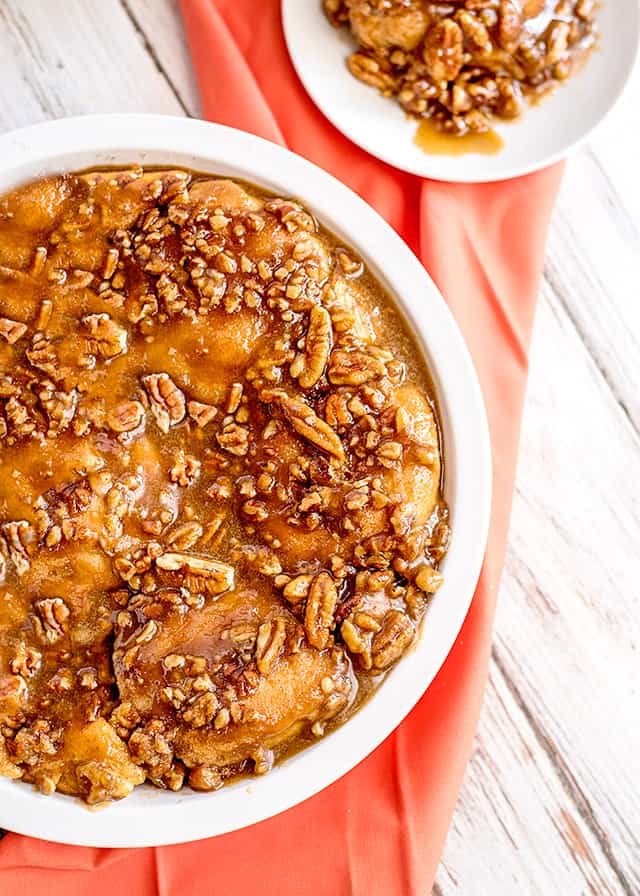 a pie plate full of easy sticky buns with a pink fabric under it