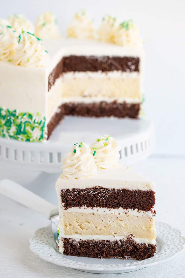 slice of chocolate guinness and baileys cheesecake cake on a white dessert plate with a serving utensil