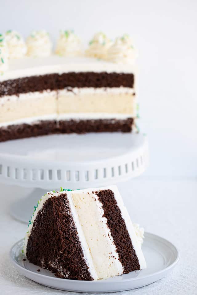 slice of cheesecake cake with the cake on a cake plate in the background