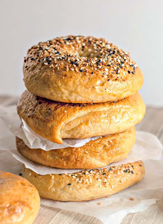 stack of homemade everything bagels with parchment paper between each one