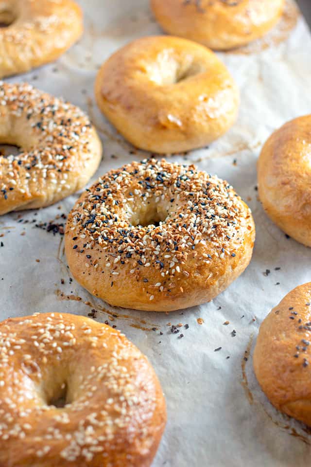 Homemade Everything Bagels laid on a piece o parchment paper