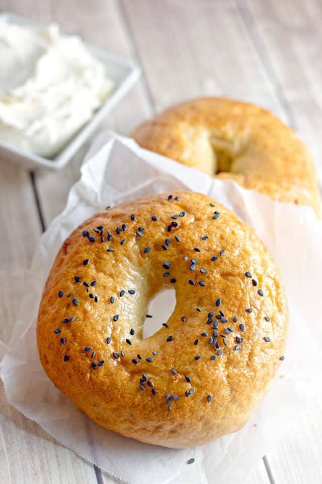 homemade bagel with sesame seeds on it laying on a piece of parchment paper