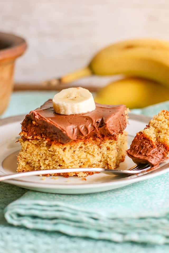 a forkful of banana cake on a plate