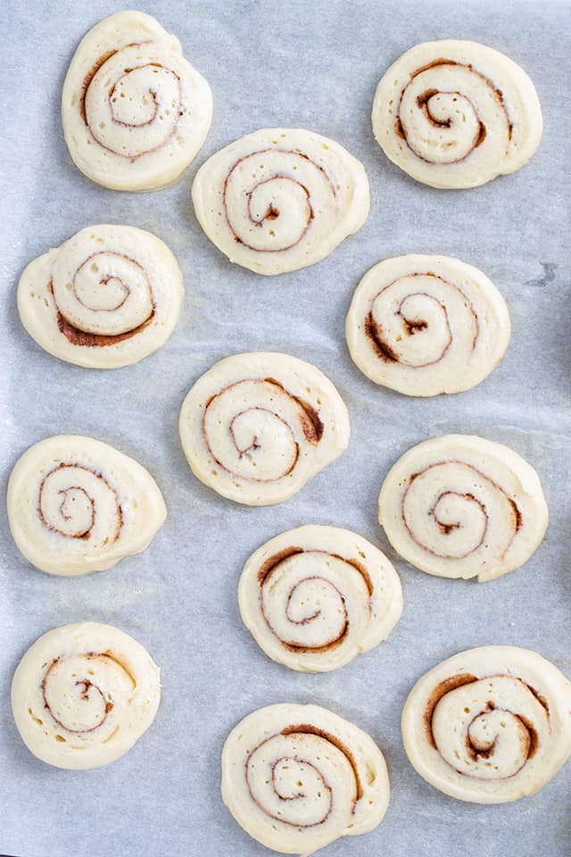 raw honey buns on a parchment lined baking sheet