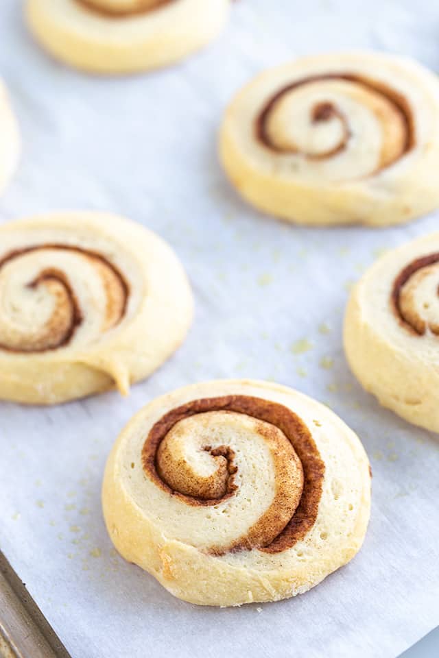 baked honey buns on a parchment lined cookie sheet