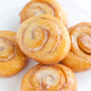 honey buns stacked on a white platter