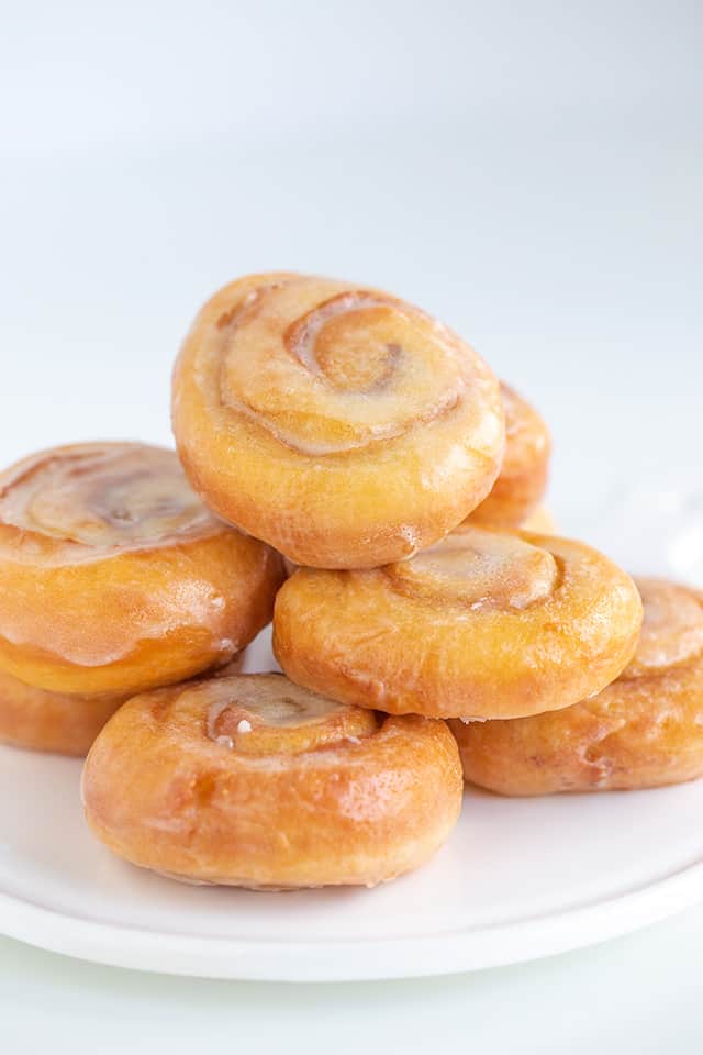 a pile of honey buns on a white plate