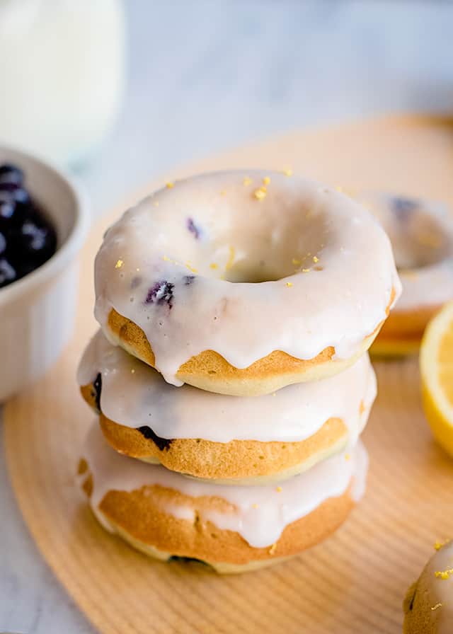 stack of donuts on a yellow place mat with lemon and donuts around it