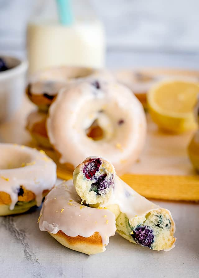 baked donut broke in half to show the blueberries with donuts around it and a yellow place mat