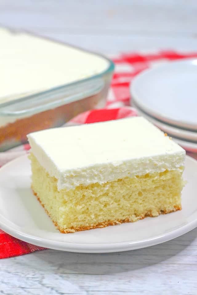 slice of depression cake on a small white plate with a red plain linen behind it