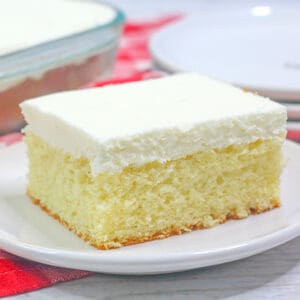 close up of vanilla cake on a small dessert plate with a red linen underneath